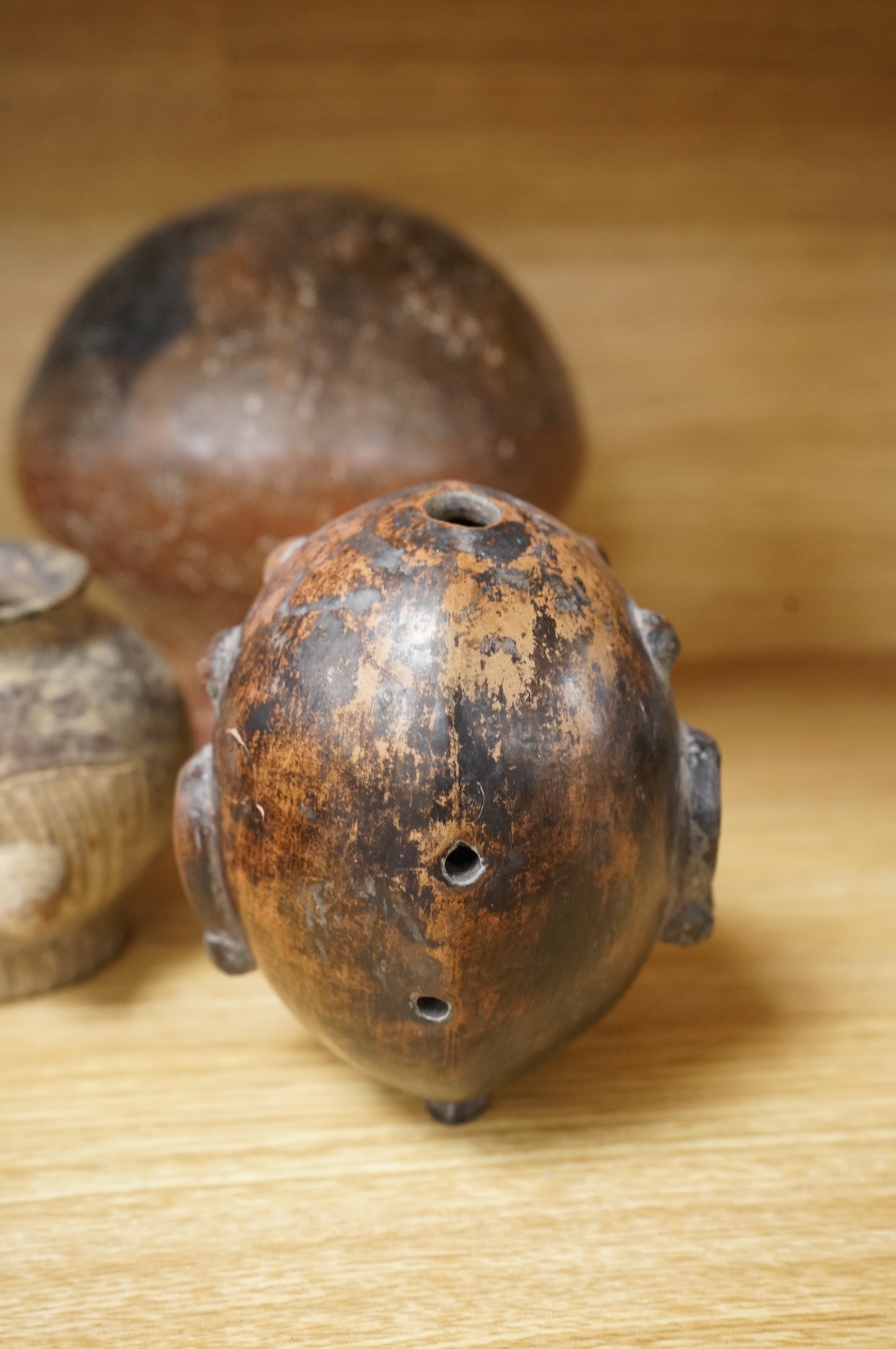 A collection of various South American vessels some in the form of grotesque heads, largest 24cm wide